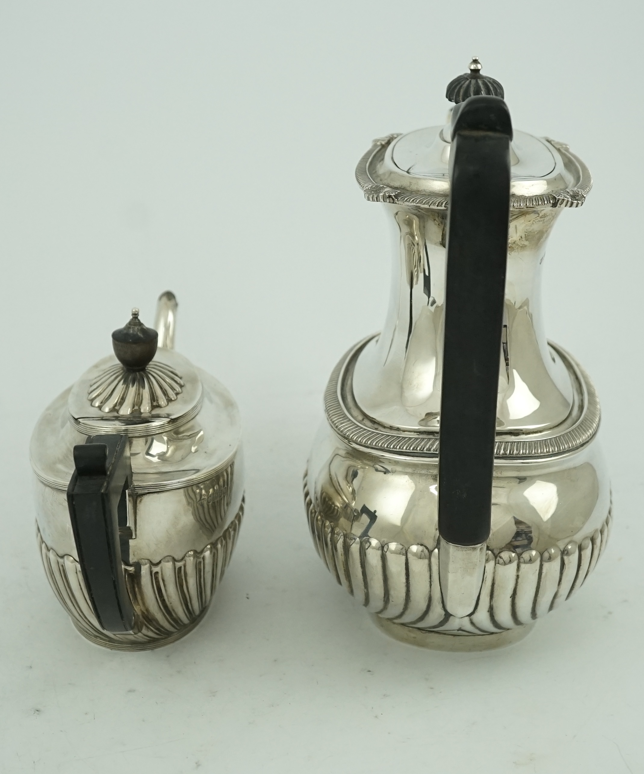 An Edwardian demi-fluted silver oval coffee pot by Mappin & Webb, Sheffield, 1902 and a similar tea pot by Henry Harrison, Sheffield, 1884